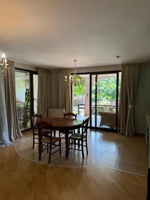 a dining room with a wooden table and chairs at Апартамент в Лозенец, Oasis Resort and Spa in Lozenets