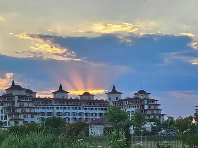 a large white building with a sunset in the background at Sunrise Apartment 14 in Obzor