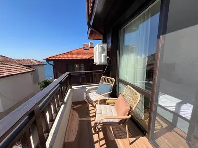 a balcony with two chairs and a window at Къща за гости Сирената in Sozopol