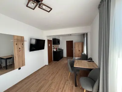 a living room with a table and chairs and a dining room at Къща за гости Сирената in Sozopol