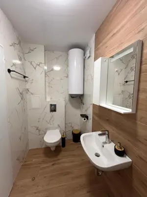 a bathroom with a white sink and a toilet at Къща за гости Сирената in Sozopol