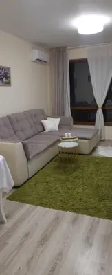 a living room with a couch and a green rug at Apartament Silvi Super View in Varna City