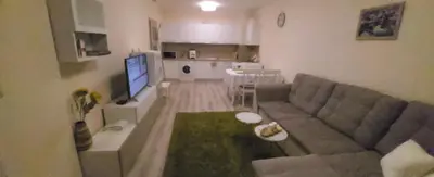 a living room with a couch and a television at Apartament Silvi Super View in Varna City