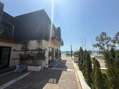 a building with the sun shining on the side of it at Studio Port Nessebar in Nesebar