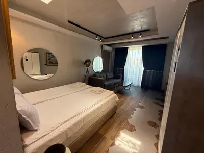 a bedroom with a large bed and a mirror at Studio Port Nessebar in Nesebar
