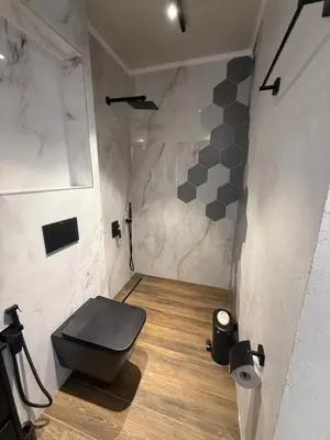 a bathroom with a black toilet in a room at Studio Port Nessebar in Nesebar