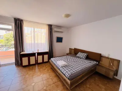 a bedroom with a bed and a large window at Guest House Polikseni in Sozopol