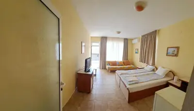 a hotel room with a bed and a television at Guest House Polikseni in Sozopol