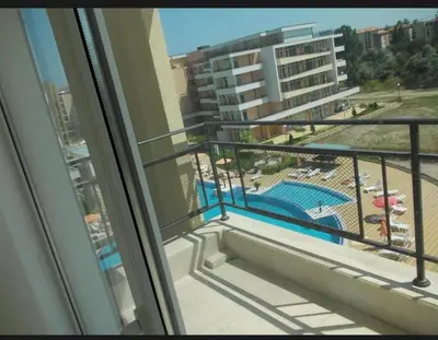 a balcony with a view of a pool and a building at Уютная студия на Солнечном берегу in Sunny Beach