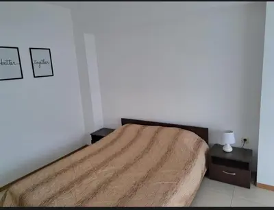 a bedroom with a large bed and two night stands at Уютная студия на Солнечном берегу in Sunny Beach