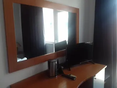 a mirror on a wall above a desk with a television at Alexandrov Residence Studio in Nesebar