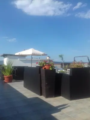 a patio with potted plants and an umbrella at Alexandrov Residence Studio in Nesebar