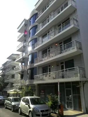 two cars parked in front of a tall building at Alexandrov Residence Studio in Nesebar