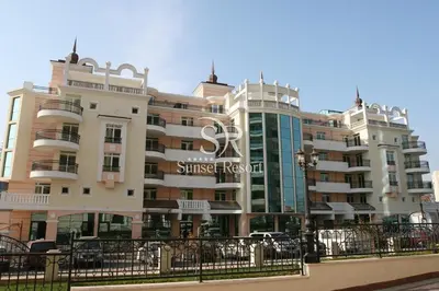 a large building with a sign on the side of it at Сънсет резорт Поморие in Pomorie