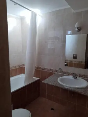a bathroom with a sink and a tub and a toilet at Сънсет резорт Поморие in Pomorie