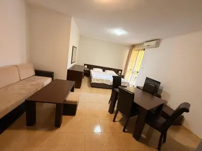 a living room with a couch and a table and a bed at South Beach Vigo Studio in Nesebar