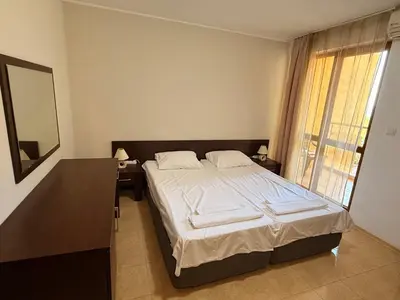 a bedroom with a bed with a mirror and a window at South Beach Vigo Studio in Nesebar