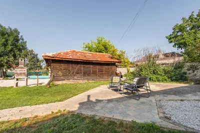 a patio with a chair and a log cabin at Augusta's Authentic Farm House in Pchelnik