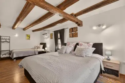 a bedroom with two beds and wooden ceilings at Augusta's Authentic Farm House in Pchelnik