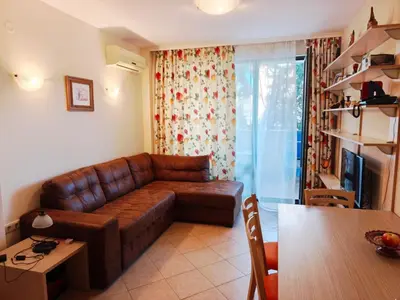a living room with a brown leather couch and a table at Royal Sun - Vaio - 1BR Apt with Balcony in Sunny Beach