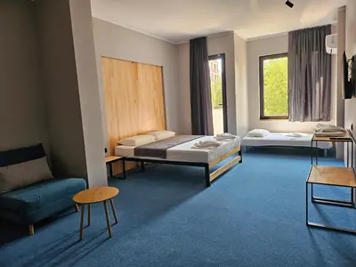 a hotel room with two beds and a couch at O'clock bed & SPA in Burgas City