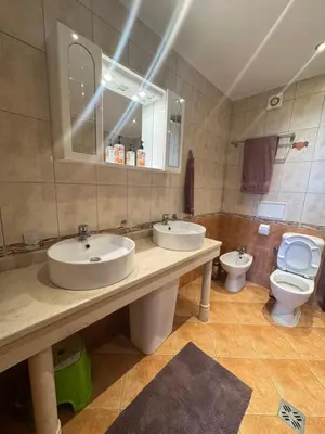 a bathroom with two sinks and a toilet at Каса Реал апартамент с 2 спальнями in Sveti Vlas