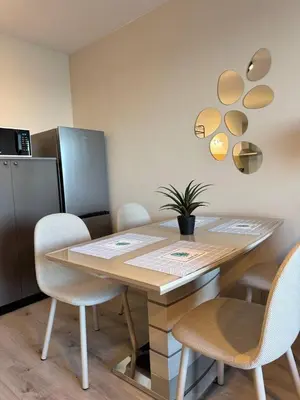a dining room with a table with chairs and a refrigerator at Ипанемма апартамент с 1 спальней in Sveti Vlas