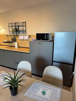 a kitchen with a refrigerator and a table with chairs at Ипанемма апартамент с 1 спальней in Sveti Vlas