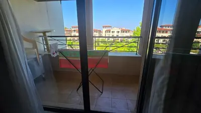 a room with a glass table and a balcony at Green Life Sozopol 80m2 in Sozopol