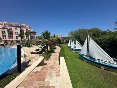 a row of boats sitting on the grass next to a pool at Elegant studio - 100 m from Smokinya Beach by Flat Mаnager in Sozopol