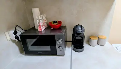 a microwave sitting on a counter next to a coffee maker at Elegant studio - 100 m from Smokinya Beach by Flat Mаnager in Sozopol
