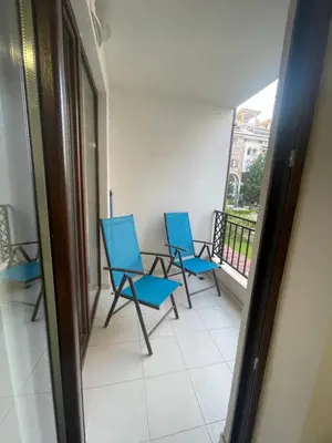 three blue chairs sitting on a balcony with a window at Апартамент у моря in Nesebar