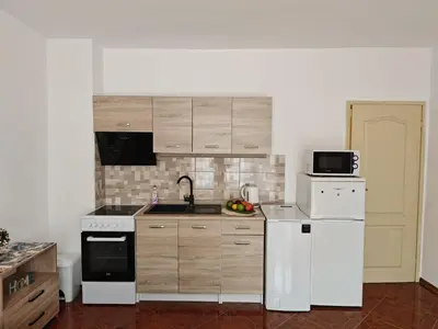 a kitchen with white appliances and wooden cabinets at SUN LIGHT Slnečné pobrežie in Sunny Beach