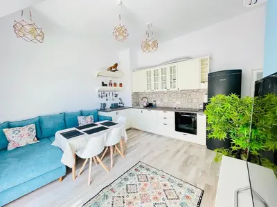 a living room with a blue couch and a kitchen at 2BR Vintage Residence - free parking in Varna City