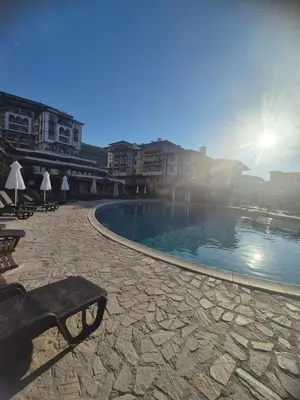a swimming pool with a bench and some buildings at Etara 4 in Sveti Vlas