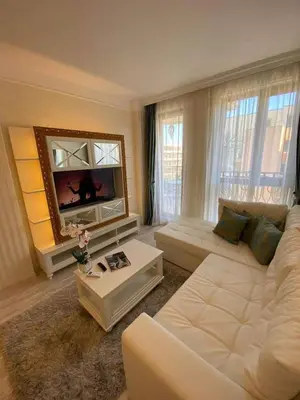 a living room with a white couch and a tv at Harmony 20 in Sveti Vlas