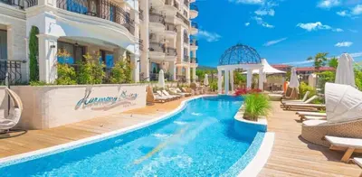 a pool at a hotel with chairs and a building at Harmony 20 in Sveti Vlas