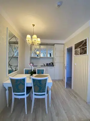 a dining room with a white table and blue chairs at Harmony 20 in Sveti Vlas