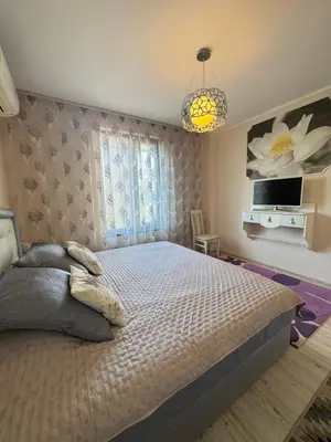 a bedroom with a large bed and a tv at Эстебан с 2 спальнями in Nesebar