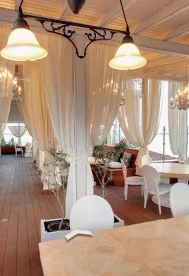a room with white chairs and tables and curtains at Каса реал с 2 спальнями 2 этаж in Sveti Vlas