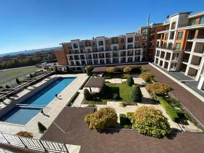 an apartment complex with a swimming pool in a courtyard at Premier Fort Beach in Sveti Vlas
