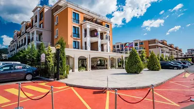 a parking lot with cars parked in front of a building at Premier Fort Beach in Sveti Vlas
