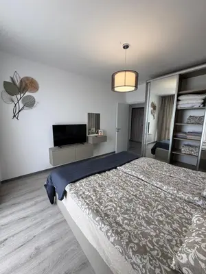 a bedroom with a large bed and a tv at Ипанемма с 1 спальней корпус А in Sveti Vlas