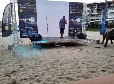 a man standing on a stage on the beach at Kombani 3 in Sveti Vlas