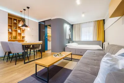a living room and dining room with a couch and a table at Sam Centre Harmony 1-Bedroom in Burgas City