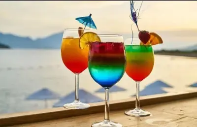 four wine glasses sitting on a table near the water at Rainbow 2 Aparthotel Complex in Sunny Beach