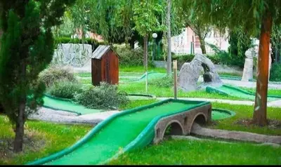 a playground with a green slide in a park at Rainbow 2 Aparthotel Complex in Sunny Beach