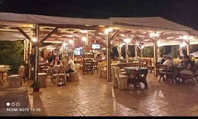 a group of people sitting at a restaurant at night at Rainbow 2 Aparthotel Complex in Sunny Beach