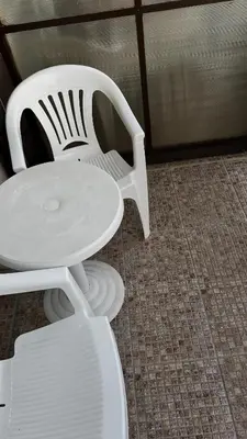 a white table and chair sitting next to a room at Sunny Beach Fort Noks Orchid Apartment in Sunny Beach
