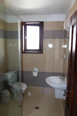 a bathroom with a sink and a toilet and a window at Villa Elmar in Kiten